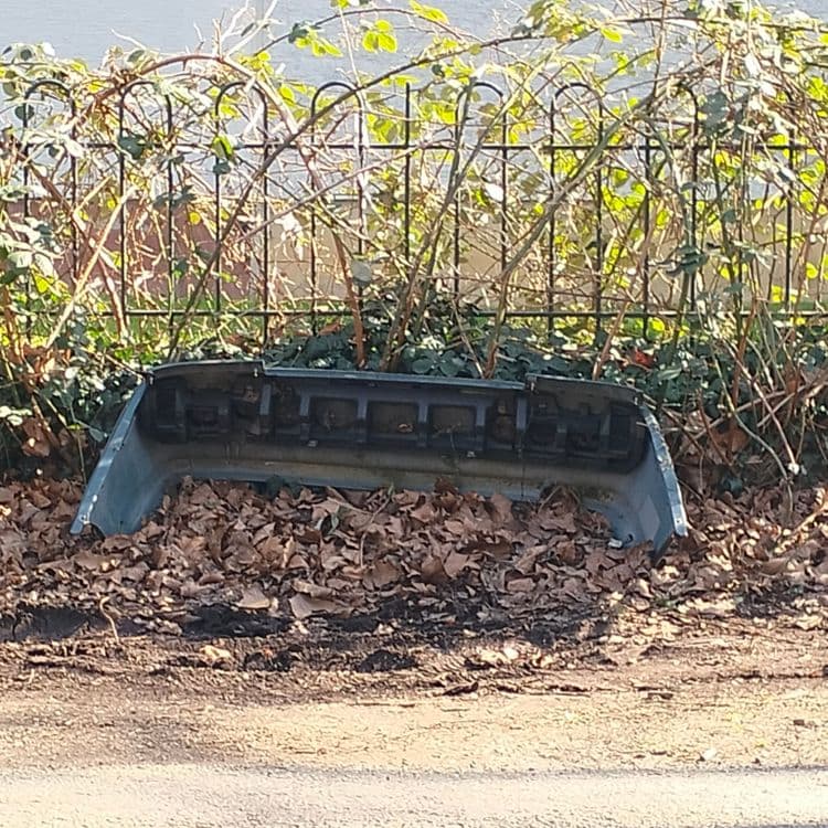 Pare choc de voiture abandonné au bord de la route 
