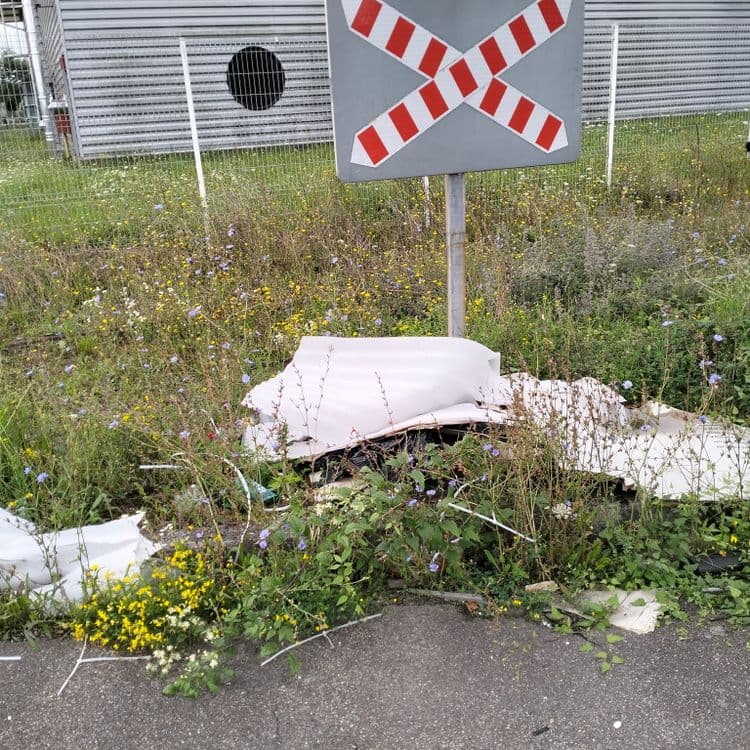 Déchets divers abandonnés au bord d'une voie ferrée 