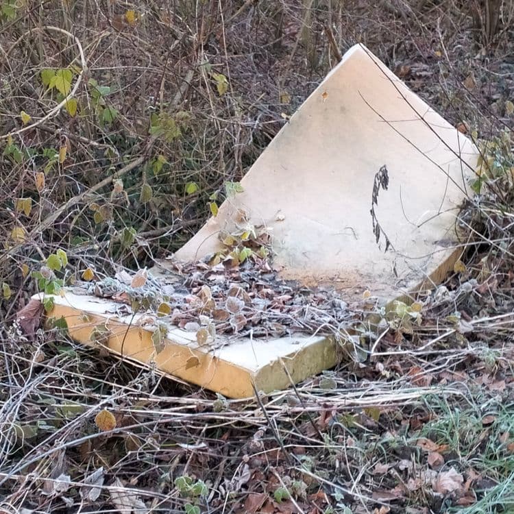 Sacs poubelles, matelas en mousse et déchets divers abandonnés au bord de la route 