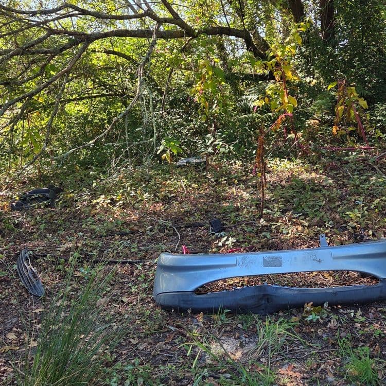 Voici l'analyse des déchets présents sur l'image :

Un pare-chocs automobile en plastique (environ 5 kg, quantité : 1).
Un morceau de calandre de voiture, également en plastique (environ 0,5 kg, quantité : 1).
Divers débris automobiles, comprenant des fragments de plastique et de métal (environ 2 kg, quantité : indéterminée).
