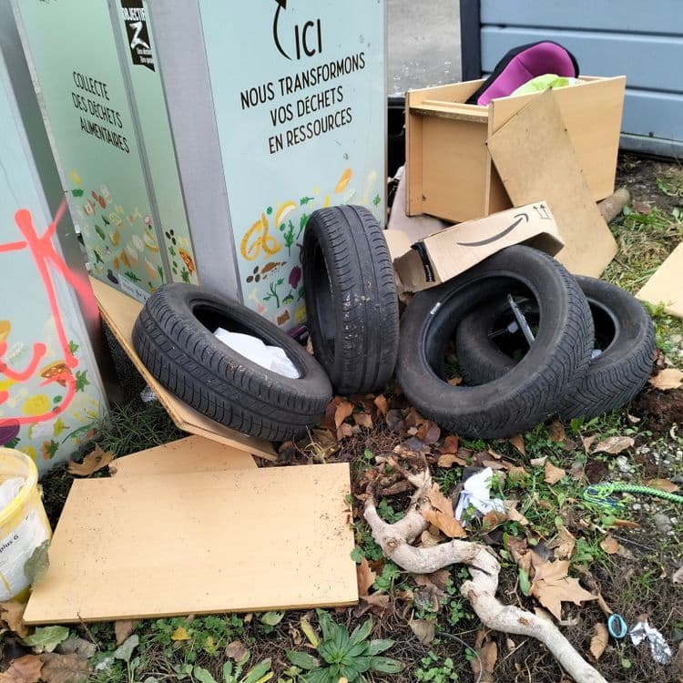 Parking public utilisé comme dépotoire, pneus usagés et déchets divers 