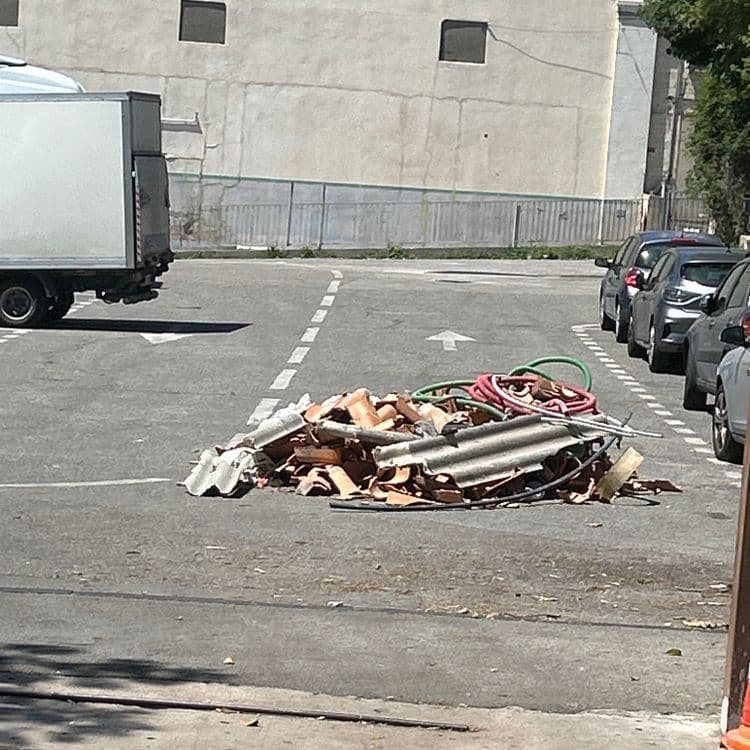 Voici l'analyse des déchets présents sur l'image :

- Débris de tuiles en terre cuite : Environ 15 kg, représentant une quinzaine de morceaux.
- Fragments de plaques de fibrociment : Environ 8 kg, comprenant 3 à 4 éléments distincts.
- Tuyaux en plastique (rouge et vert) : Environ 3 kg, correspondant à 2 tuyaux.
- Divers câbles électriques : Environ 2 kg.
- Petits déchets divers (bois, plastiques) : Environ 1 kg.
