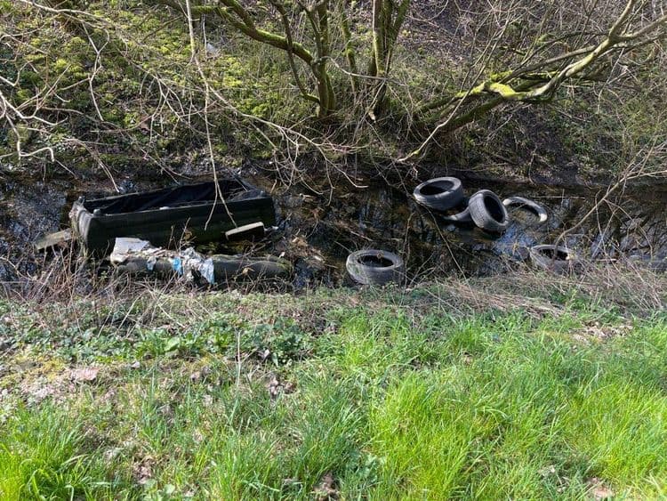 Plastique,canapé et pneus de chaque côté de la route dans le ruisseau 