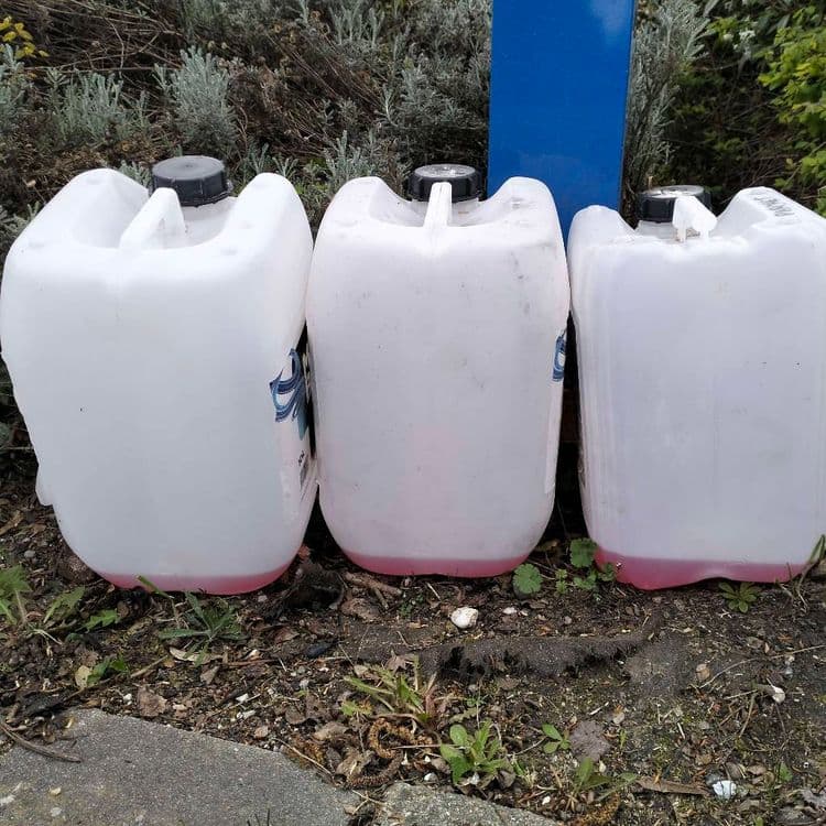 3 bidons presque vides abandonnés au bord de la route 