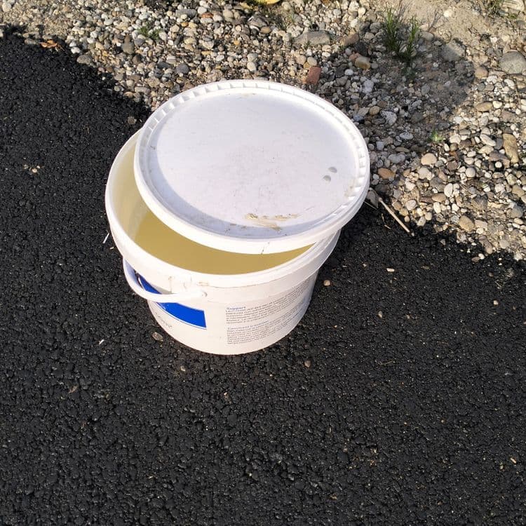Pot de peinture posé sur le trottoir, encore rempli