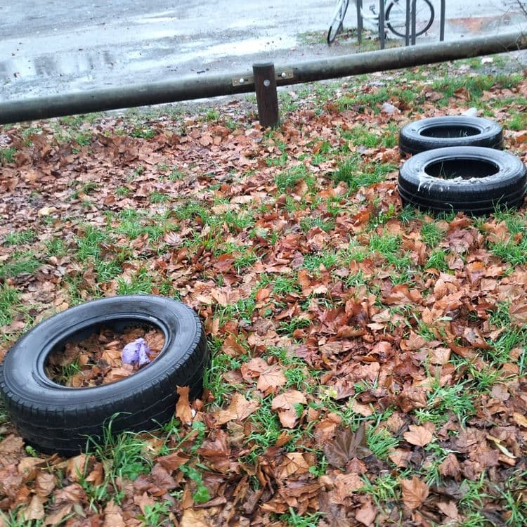 Pneus usagés abandonnés sur un parking public 