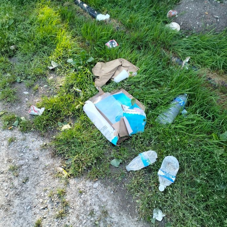 Pneus usagés et déchets divers abandonnés sur un parking public 