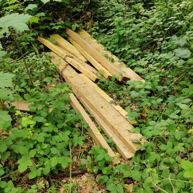 Voici une analyse des déchets présents sur l'image :

Plusieurs planches de bois sont visibles, estimées à environ 30 kg au total. On dénombre environ 10 planches de différentes longueurs. 
