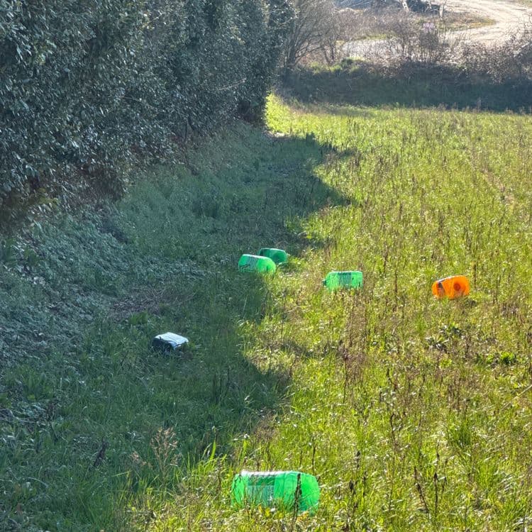 La photo montre différents déchets abandonnés dans un espace vert.  Il s'agit principalement de bouteilles en plastique, dont la plupart semblent être des contenants de boissons gazeuses de couleur verte. On observe également une bouteille orange.  

On peut estimer le poids total des déchets de plastique vert à environ 2 kg.  Il y a au moins 5 bouteilles de ce type,  leur poids individuel variant probablement entre 0.3 et 0.5 kg.

La bouteille orange, quant à elle,  pèse probablement environ 0.3 kg.

Ces estimations sont basées sur les tailles apparentes des bouteilles sur la photo et la connaissance du poids moyen de ce type de contenants.  Il est possible que le poids réel diffère légèrement de ces estimations.
