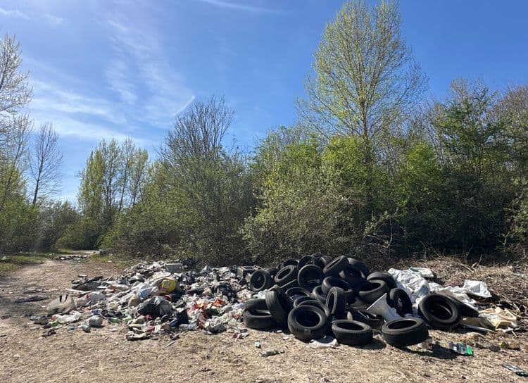 Décharge sauvage contenant pneus, bouteilles en plastique, vêtements, cartons. Verre 