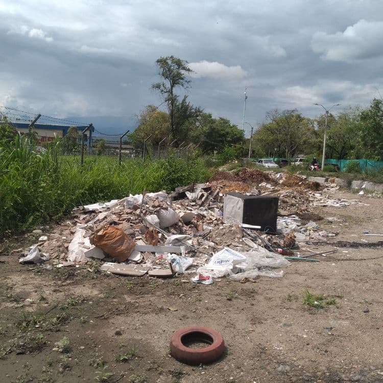 Acumulación de residuos en esquina de carretera.