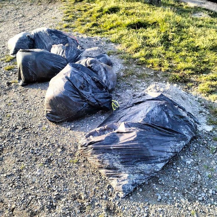 Sacs de terre et de sable abandonnés au bord d'un ruisseau 