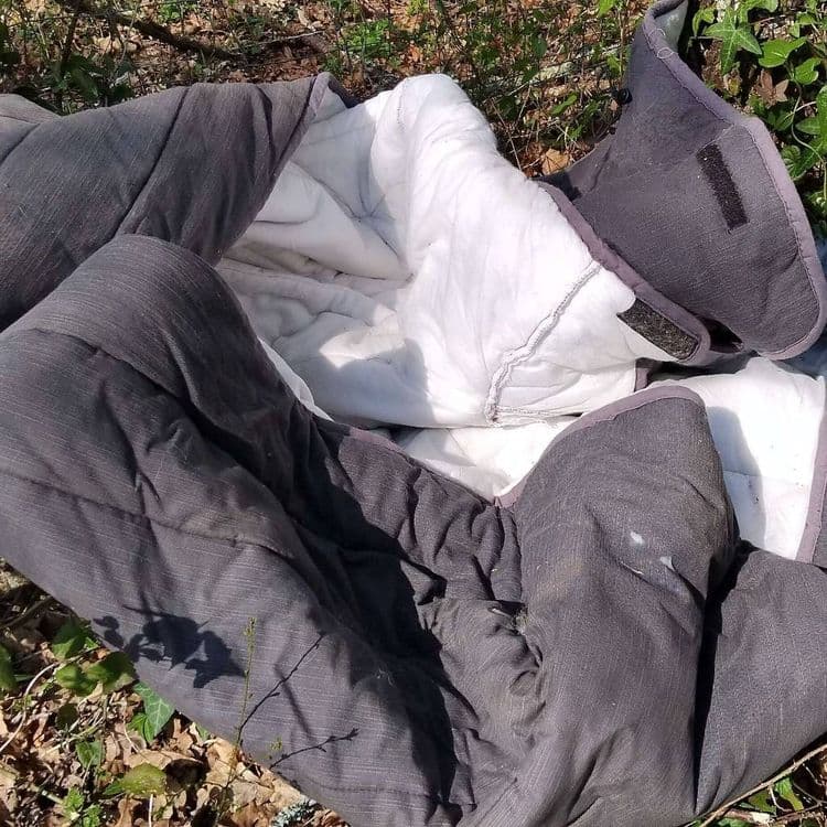 Une housse en tissu déposée en bord de route. 