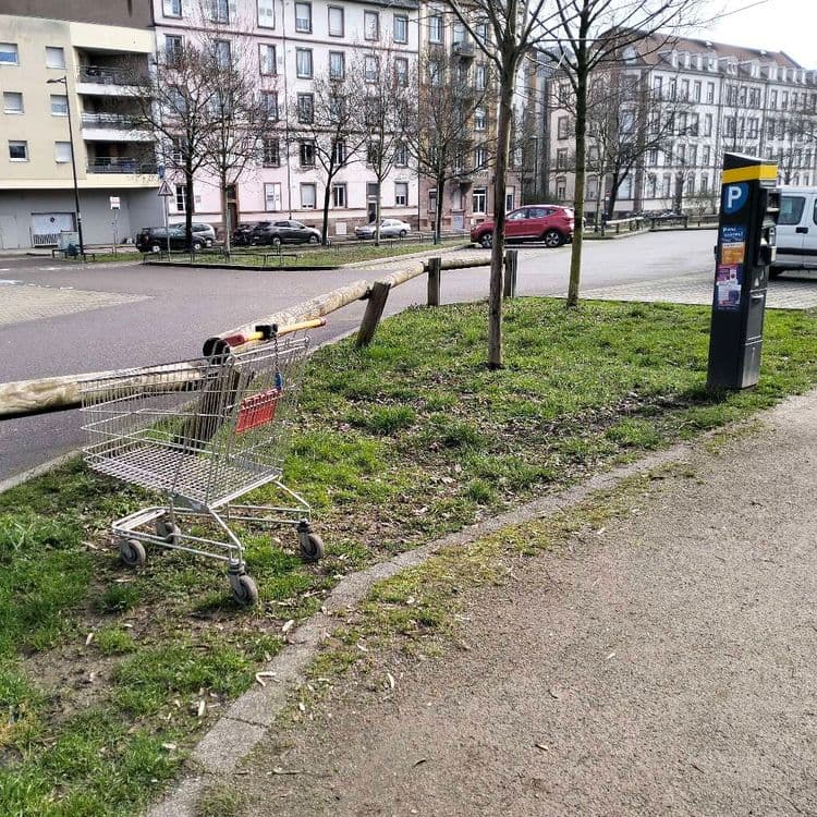 Caddie de supermarché abandonné sur un parking public 