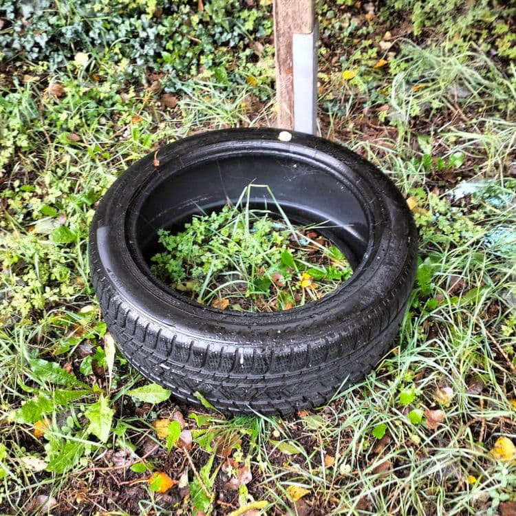 Pneu usagé abandonné sur un parking public 