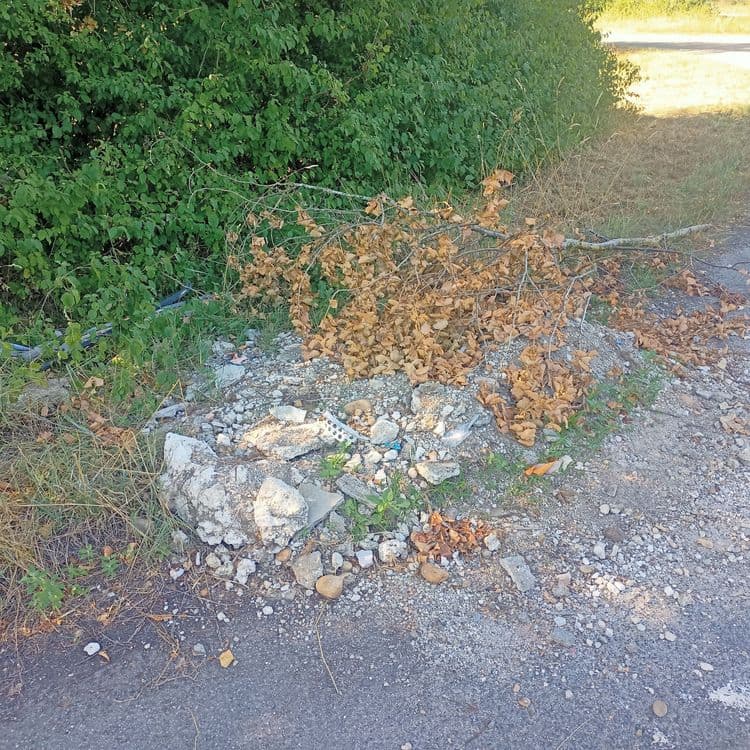 T'as de gravats, plastique et bois déposé en partie sur la chaussée.