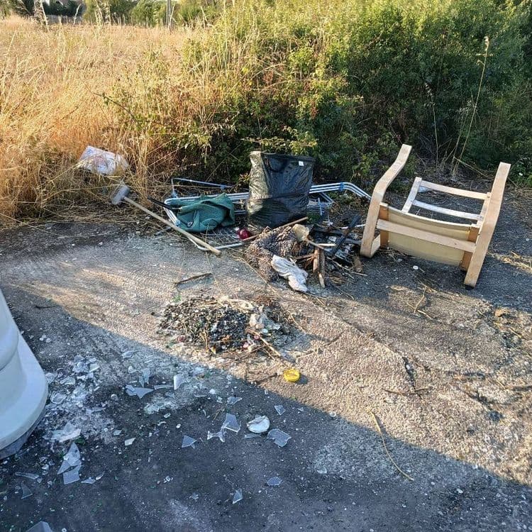 De nombreux verres cassés au sol et dans des sacs, un fauteuil et autres encombrants 