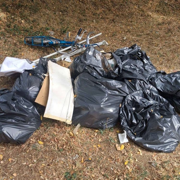Sacs de déchets. Vélo cassé et pièces détachées d’un mécanisme type store 