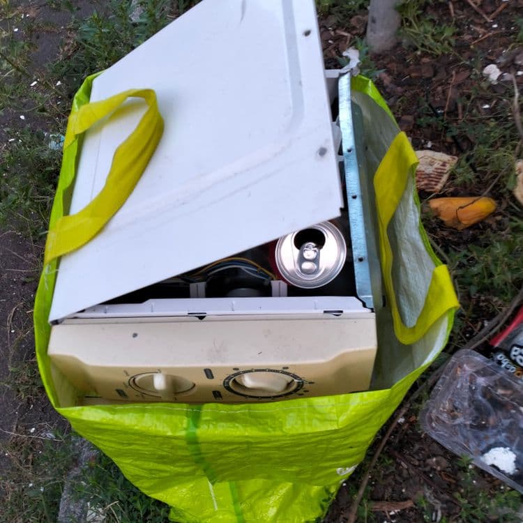 Appareil ménager et déchets divers déposés sur le trottoir 