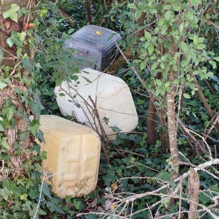 Bidons plastiques vides en bordure du chemin à proximité de la route 
