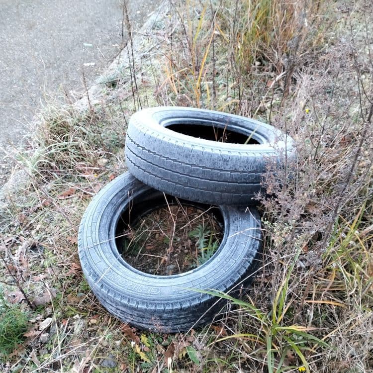 Deux pneus usagés abandonnés en zone commerciale 