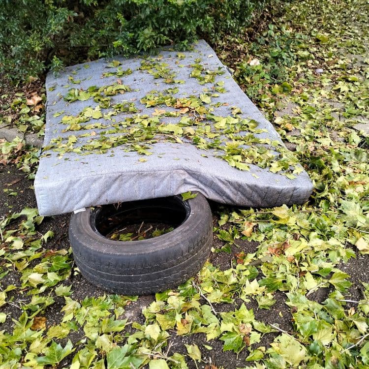 Pneu et matelas abandonnés sur un parking public 