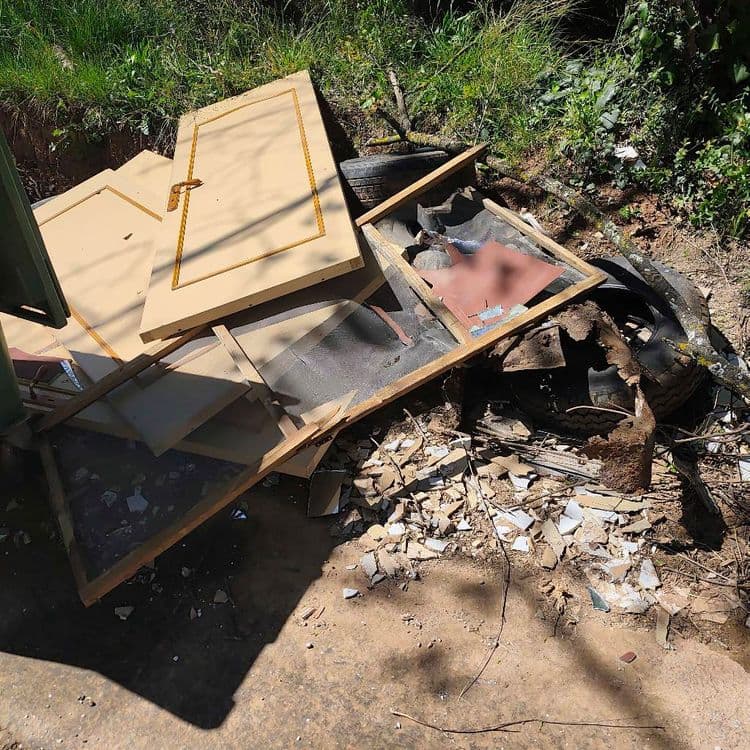 Voici une estimation des déchets présents sur la photo :

*   **Portes en bois:** Environ 2 portes complètes, estimées à 15 kg chacune.
*   **Cadres de fenêtres:** Environ 3 cadres, entre 5 et 10 kg chacun, selon la taille et le matériau.
*   **Débris de carrelage/faïence:** Une quantité importante, estimée à environ 20 kg.
*   **Pneus:** Au moins 2 pneus visibles, pesant environ 8 kg chacun.
*   **Divers débris de construction:** Bois, métal, plastiques, environ 10 kg.