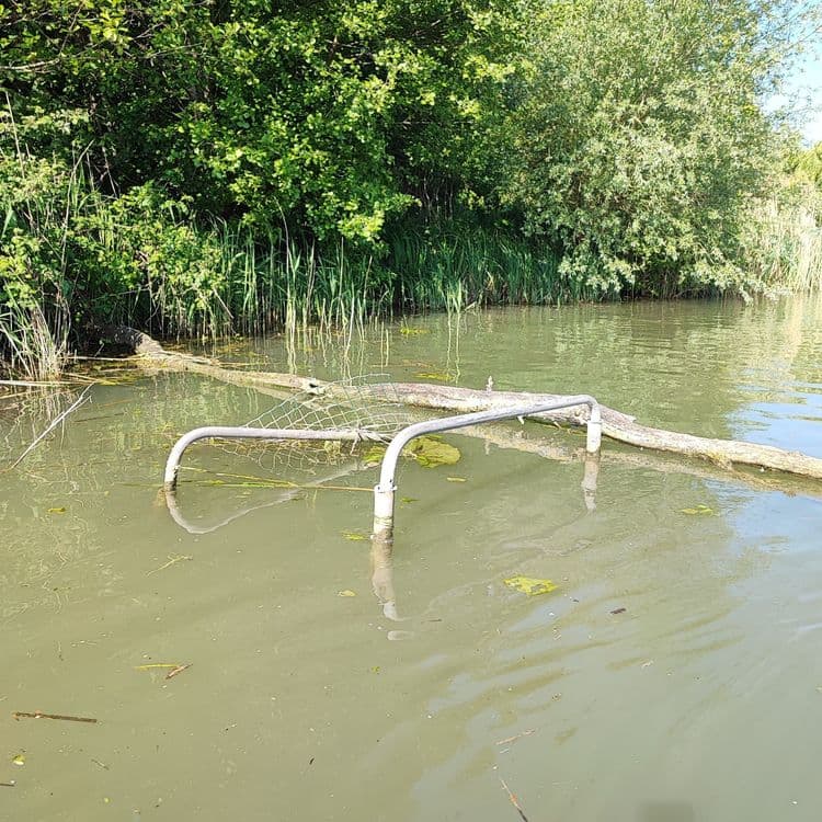 Voici l'analyse des déchets visibles sur l'image :

On peut identifier une structure métallique immergée, probablement un ancien mobilier urbain ou un élément de clôture, avec un poids estimé à environ 10-15 kg. Il y a également la présence de déchets organiques naturels, tels que des feuilles mortes, des branches et des algues, disséminés dans l'eau. La quantité de ces déchets est difficile à estimer en poids, mais pourrait représenter environ 1-2 kg.