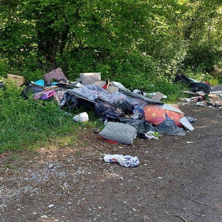 Voici une estimation des déchets présents sur l'image :

*   **Déchets textiles :** Il y a des couvertures, des coussins et potentiellement des vêtements. Estimation : environ 15 kg. Quantité : plusieurs pièces.
*   **Sacs poubelles :** Plusieurs sacs poubelles noirs sont visibles. Estimation : environ 10 kg. Quantité : environ 5 sacs.
*   **Divers :** On aperçoit des cartons, des objets en plastique divers, et des déchets papiers. Estimation : environ 8 kg. Quantité : difficile à estimer précisément en raison de la variété.
*   **Matelas/Sommier :** Un élément qui ressemble à un sommier ou une partie de matelas est présent. Estimation : environ 10 kg. Quantité : 1
*   **Pneus :** au moins 1 pneu est visible. Estimation : environ 8 kg. Quantité : 1
*   **Divers (non identifiés) :** Des déchets divers qui ne peuvent pas être identifiés précisément sont présents. Estimation : environ 5 kg. Quantité : variable.