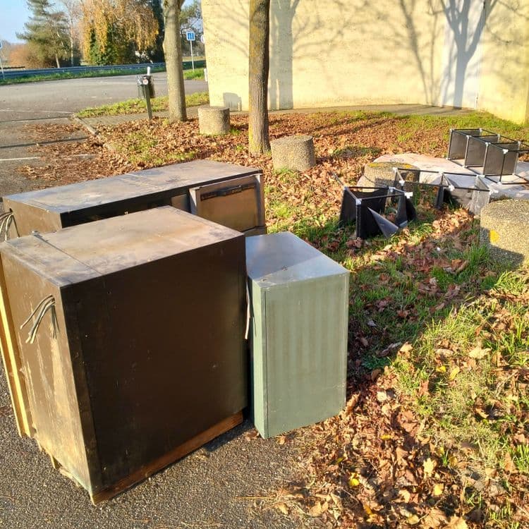 Un tapis, des étagères et deux meubles froid professionnels abandonnés sur un parking public 