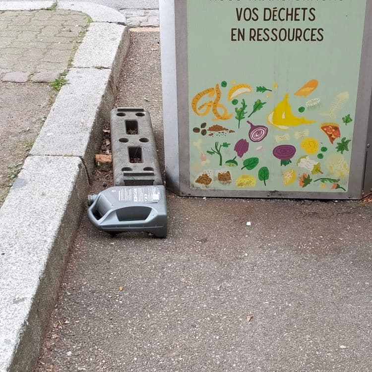 Bidon d'huile abandonné à côté de containers bio déchets 