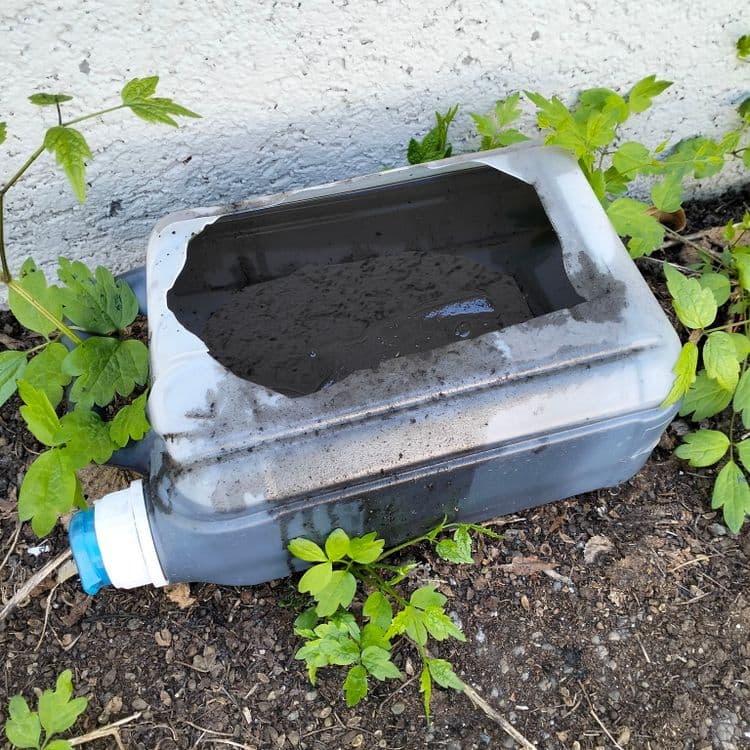 Bidon d'huile usagée après une vidange sauvage sur un parking public 