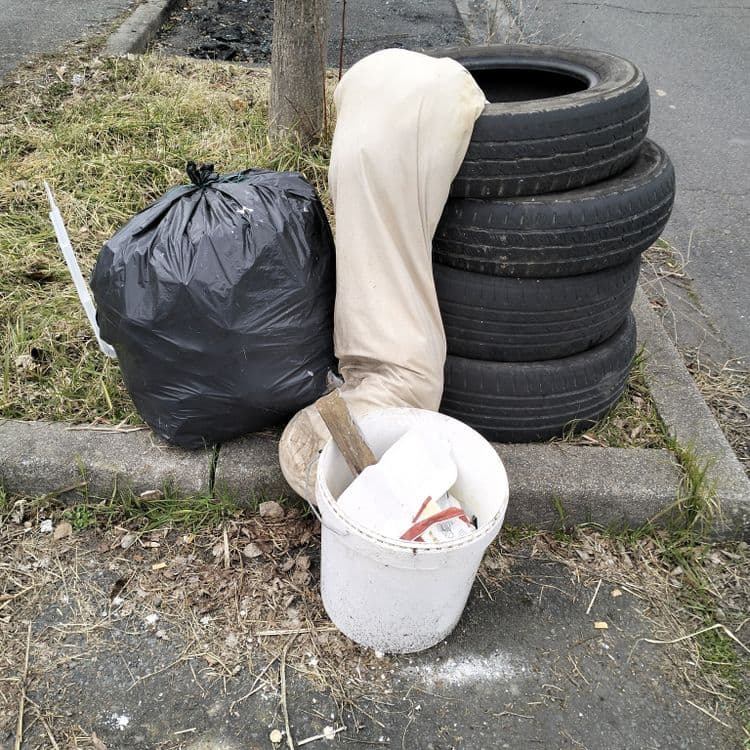 Pneus usagés et déchets divers abandonnés sur le trottoir 