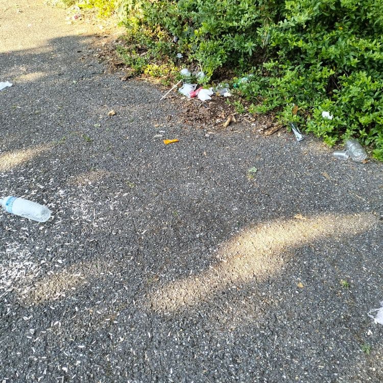 Déchets divers abandonnés sur un parking de piscine 