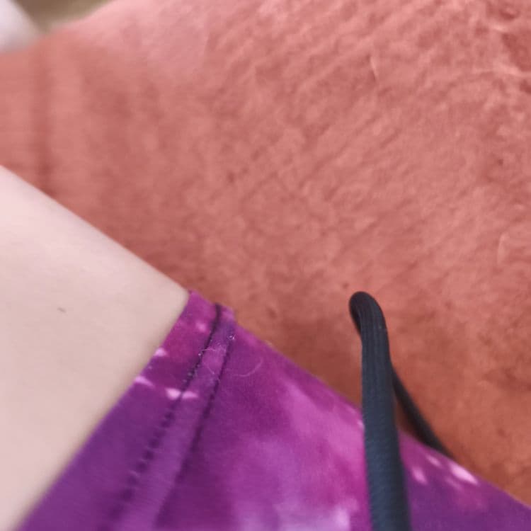 Sur la base de l'image, il semble qu'il y ait un vêtement de couleur violette présent. Le poids de ce vêtement est estimé à environ 0.1 kilogramme. Il y a une seule pièce de vêtement visible. De plus, il y a la présence d'un lacet noir. Le poids estimé de ce lacet est de 0.01 kilogramme et il y a un seul lacet visible.
