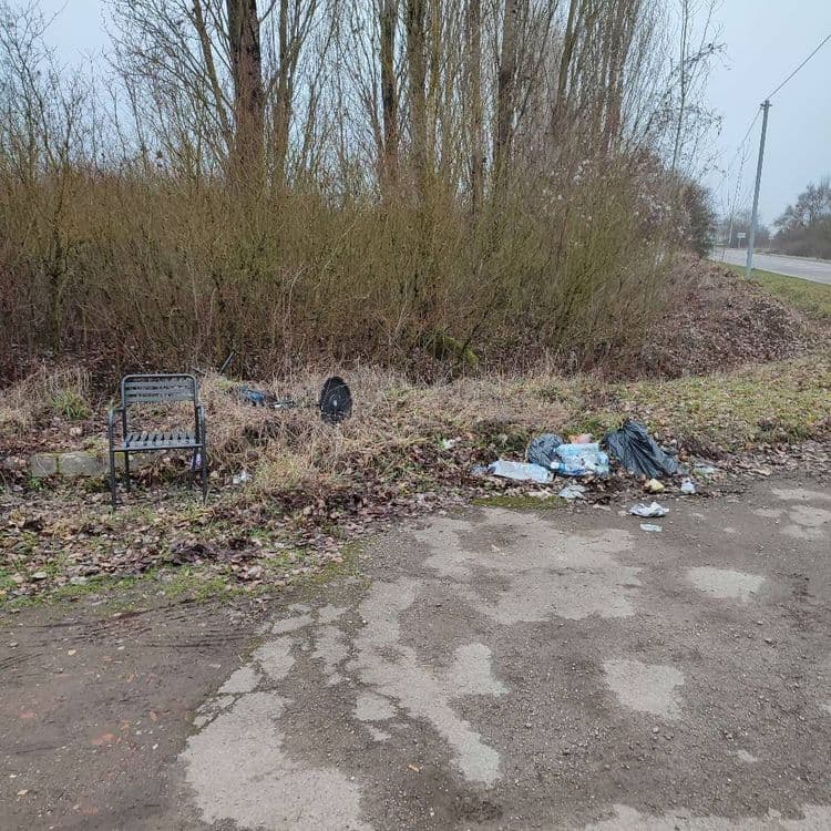 Voici une estimation des déchets présents sur la photo :

*   **Mobilier:** Une chaise métallique (environ 5 kg)
*   **Déchets ménagers en sacs plastiques:** Deux sacs poubelles contenant un mélange de déchets ménagers (environ 10 kg par sac, soit 20 kg au total). Présence de divers emballages et papiers éparpillés autour des sacs (environ 2 kg).
*   **Divers:** Un pneu (environ 8 kg).
*   **Déchets verts:** Feuilles mortes et branchages (environ 3 kg).