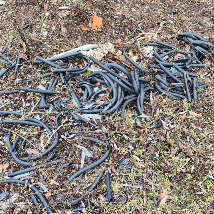 Voici une estimation des déchets présents, de leur quantité et de leur poids :

- **Déchets de construction/démolition :** Comprend des morceaux de béton (environ 30 kg), des briques (environ 10 kg), des fragments de plâtre (environ 5 kg). On observe divers éléments épars, ce qui rend difficile une estimation précise de la quantité totale.
- **Pneumatique :** 1 pneu, estimé à environ 10 kg.
- **Plastiques divers :** Bouteilles en plastique (environ 1 kg pour 5 bouteilles), fragments de jouets en plastique (environ 0.5 kg), tuyaux en PVC (environ 2 kg pour les sections visibles), et divers autres éléments en plastique (environ 1 kg). La quantité de plastique est importante et dispersée.
- **Déchets ménagers en sacs plastiques :** 2 sacs poubelles, difficiles à estimer précisément sans connaître leur contenu, mais on peut les estimer à environ 5 kg chacun.
- **Tuyaux en caoutchouc/plastique noir :** Un amas important de tuyaux, estimé à environ 15 kg.
- **Divers :** Un siège de toilette cassé (environ 2 kg), des morceaux de bois (environ 3 kg), et d'autres déchets non identifiables (environ 2 kg).

