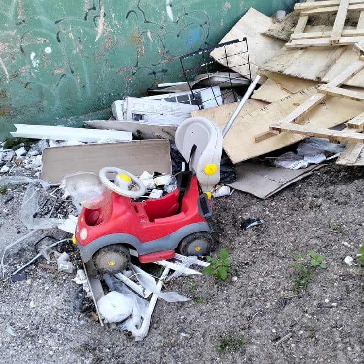 Déchets bois et divers abandonnés sur un chemin en bordure d'autoroute 