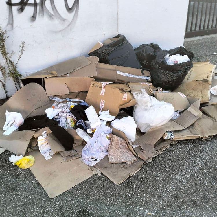 Déchets divers et mobilier abandonnés sur le trottoir en zone industrielle 