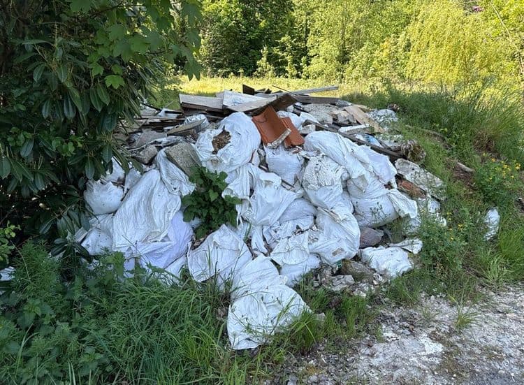 Voici une estimation des déchets présents sur la photo :

*   **Sacs de gravats :** Environ 25 sacs, contenant potentiellement des restes de béton, de plâtre, de pierres ou de tuiles. Poids estimé par sac : 20 kg. Poids total estimé : 500 kg.
*   **Débris de bois :** Différentes planches et morceaux de bois, pouvant provenir de meubles, de palettes ou de construction. Quantité estimée : 1 mètre cube. Poids total estimé : 150 kg.
*   **Tuiles et matériaux de construction divers :** Présence de quelques tuiles cassées et d'autres fragments de matériaux de construction non identifiables précisément. Quantité estimée : 0.2 mètre cube. Poids total estimé : 50 kg.