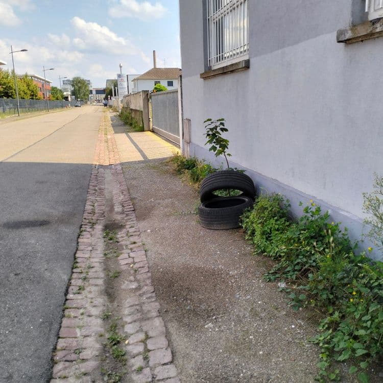 Pneus usagés au bord de la route en zone industrielle 