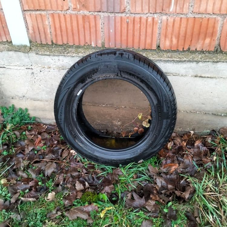 Pneu usagé abandonné à côté d'un bâtiment 