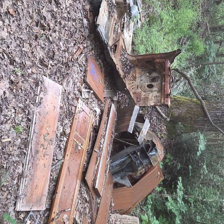 Carcasse de voiture et déchets de chantier.