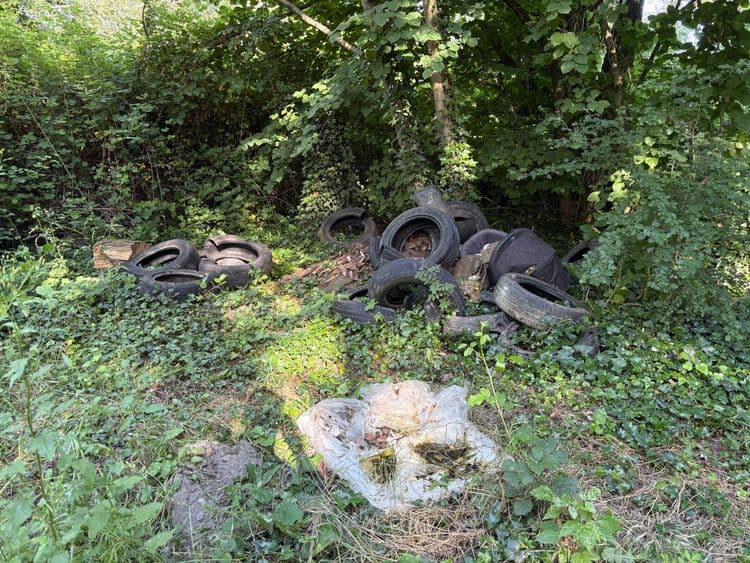 Voici l'analyse des déchets présents sur l'image :

*   **Pneus usagés :** Environ 15 pneus, estimés à environ 8 kg par pneu, soit un total de 120 kg.

*   **Sacs plastiques :** 1 sac plastique contenant des déchets organiques, estimé à 1 kg.

*   **Divers:** Un sac d'habit de poussette, estimé à 1 kg.

Le poids total estimé des déchets est d'environ 122 kg.