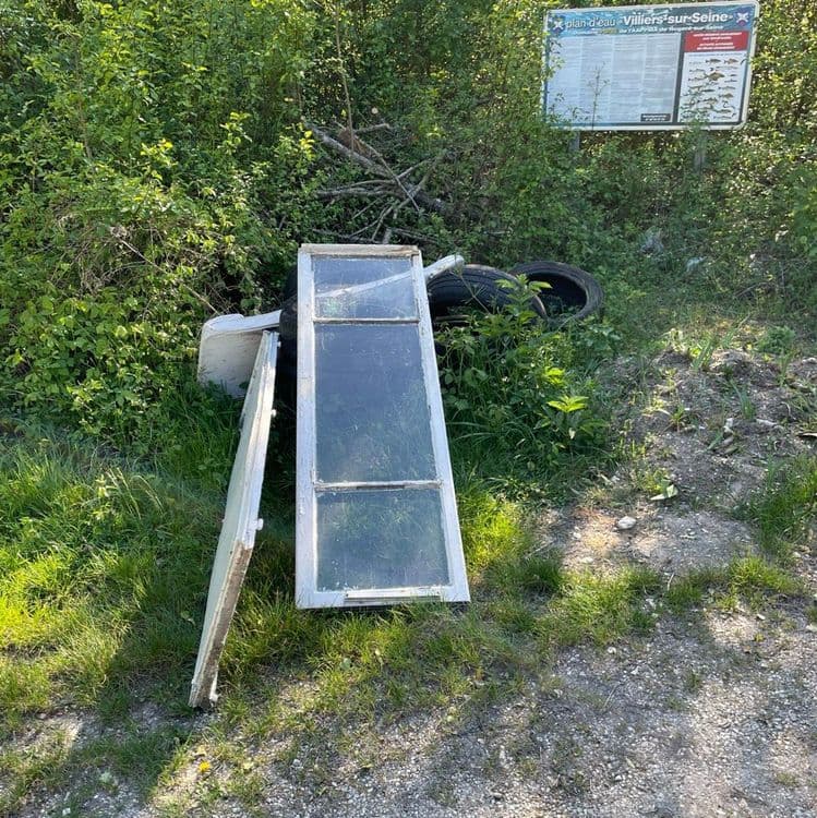 Voici une estimation des déchets présents sur la photo :

*   **Fenêtre en bois avec vitres** : 1 unité, environ 15 kg
*   **Porte en bois** : 1 unité, environ 8 kg
*   **Pneu** : 2 unités, environ 10 kg chacun, soit un total de 20 kg
*   **Divers (débris de construction, éléments sanitaires)** : environ 5 kg

