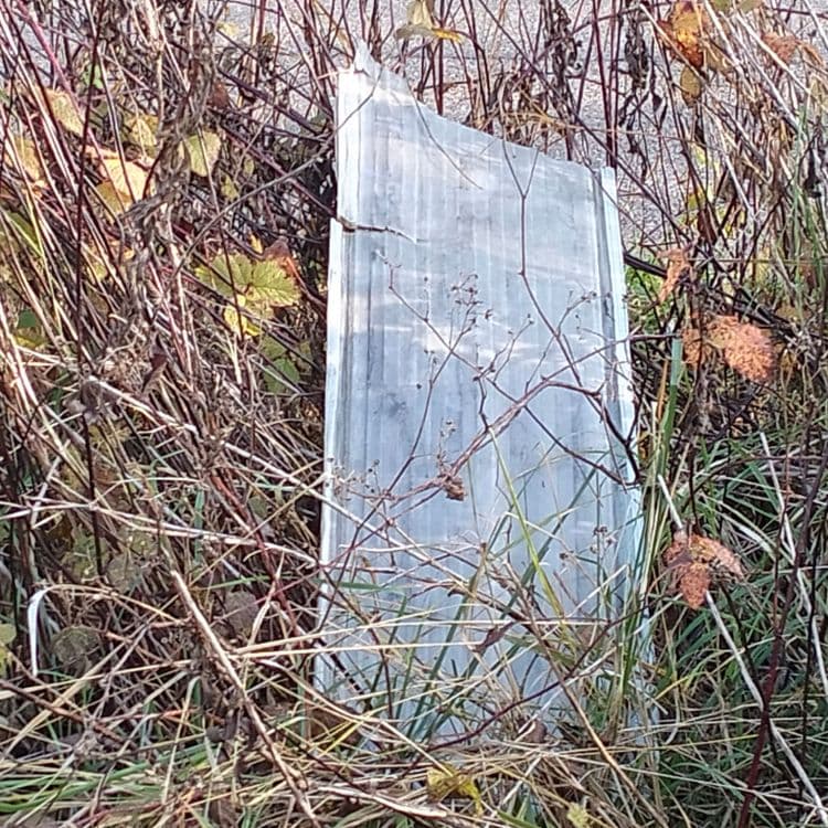 Panneau plastique abandonné au bord de la route 