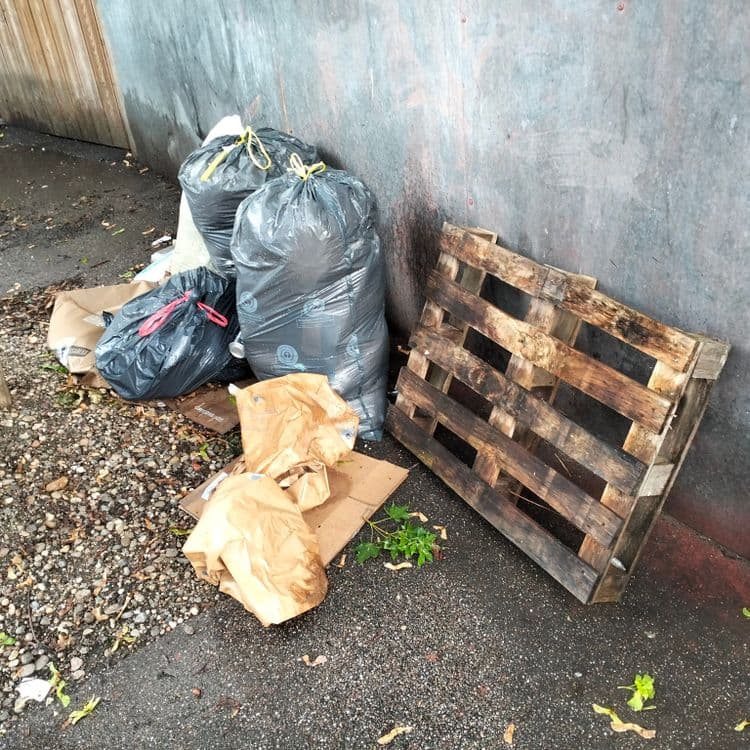 Sacs poubelles, palette, déchets divers en plein centre ville, à proximité d'habitation et de garages