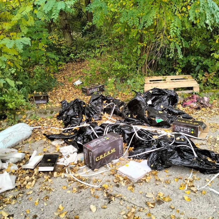 Mobilier et déchets divers abandonnés sur un chemin en zone d'activité 