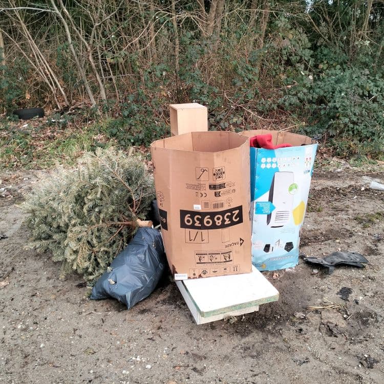 Pneus usagés et déchets divers abandonnés sur un parking public 