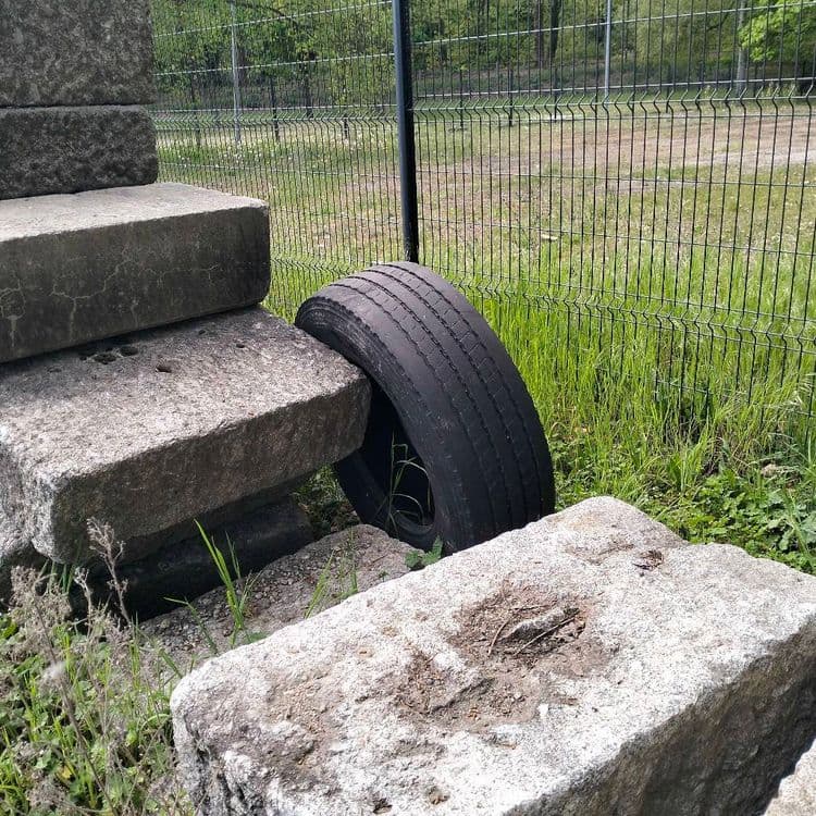 Sièges de voiture et pneu de camion abandonnés en zone industrielle 